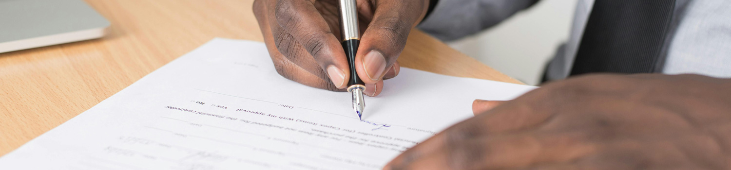 An image of a person signing a document.