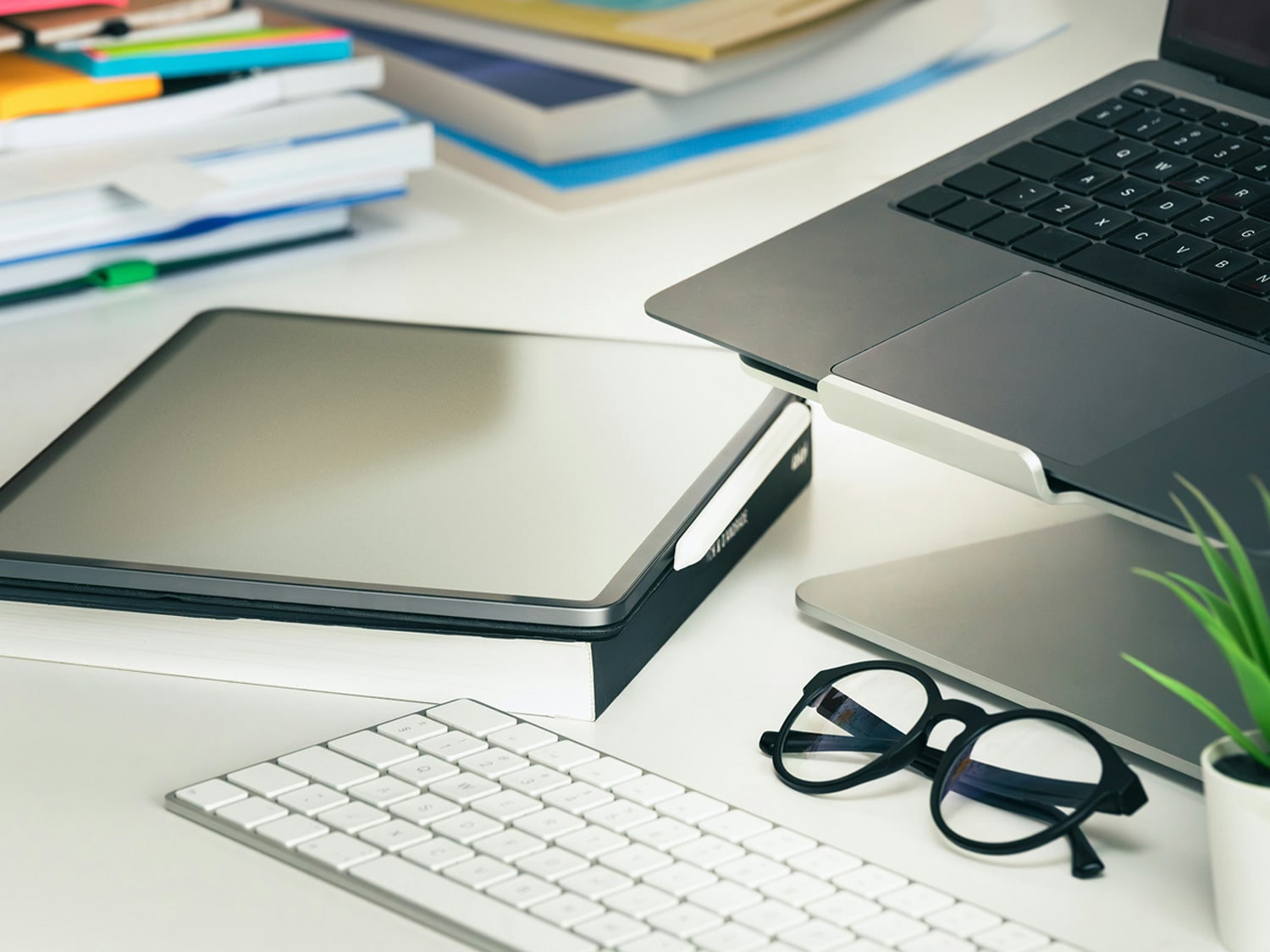 An office table with notebooks and a laptop on it.